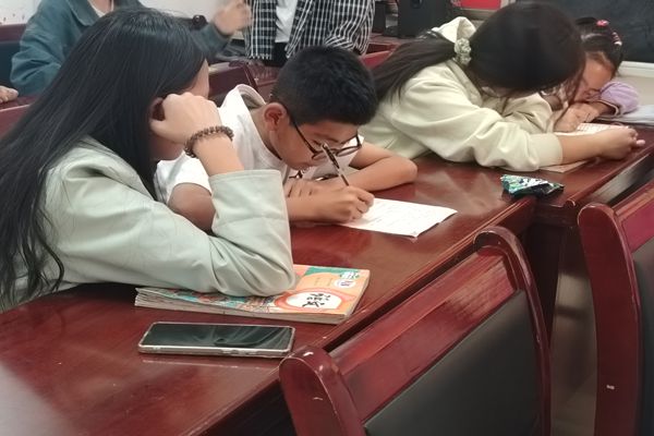 图一  志愿者认真辅导学生作业.jpg