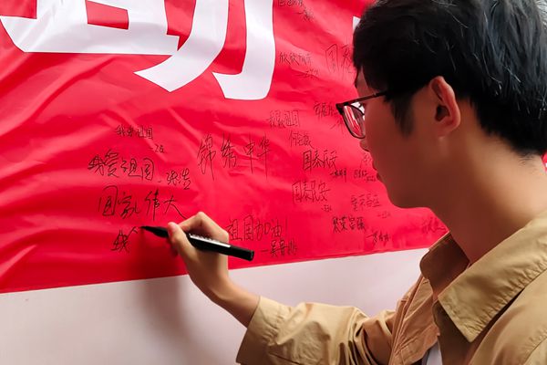 图二 参与同学在横幅上写下签名和寄语.jpg